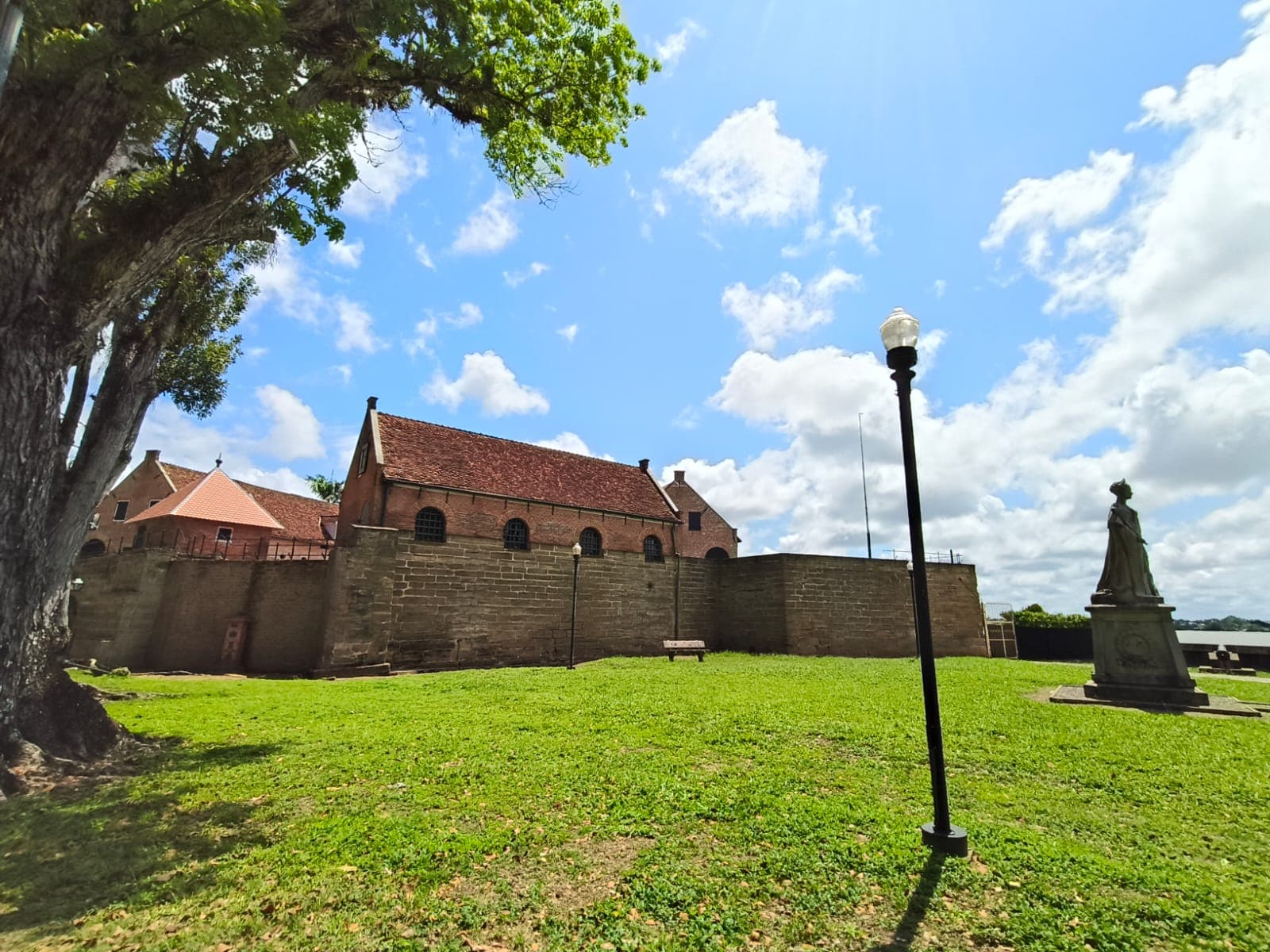 The brick walls and red roofs of Fort Zeelandia seen from the riverside lawn